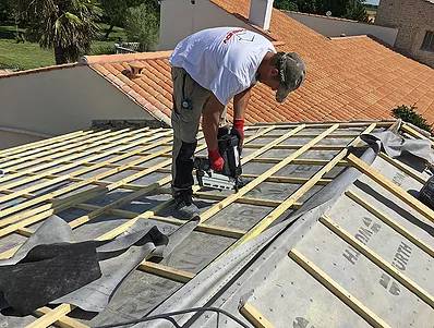 intro-renovation-toiture ouvrier Iso-Renov sur un toit entrain de fixer des liteaux