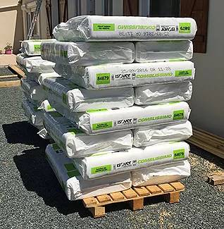 materiaux-isolation-combles Empilement de sacs d'isolant Isover pour isoler les combles de maison