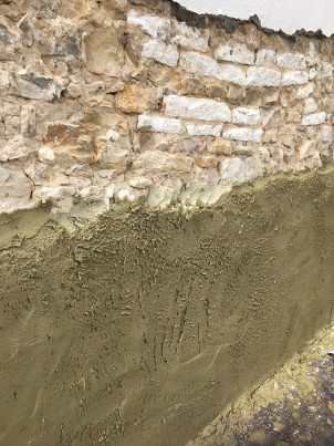 Application de pouzzolane sur un mur humide