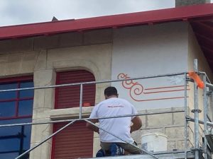 ouvrier Iso-Renov entrain d'étaler de l'enduit chaux aérienne sur une façade ancienne